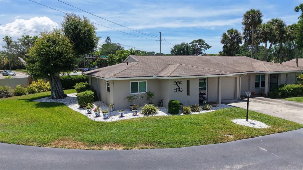 A single-story house with a beige exterior, a brown shingled roof, and a landscaped yard — 2902 CAPTIVA GARDENS DRIVE UNIT 3, SARASOTA, FL
