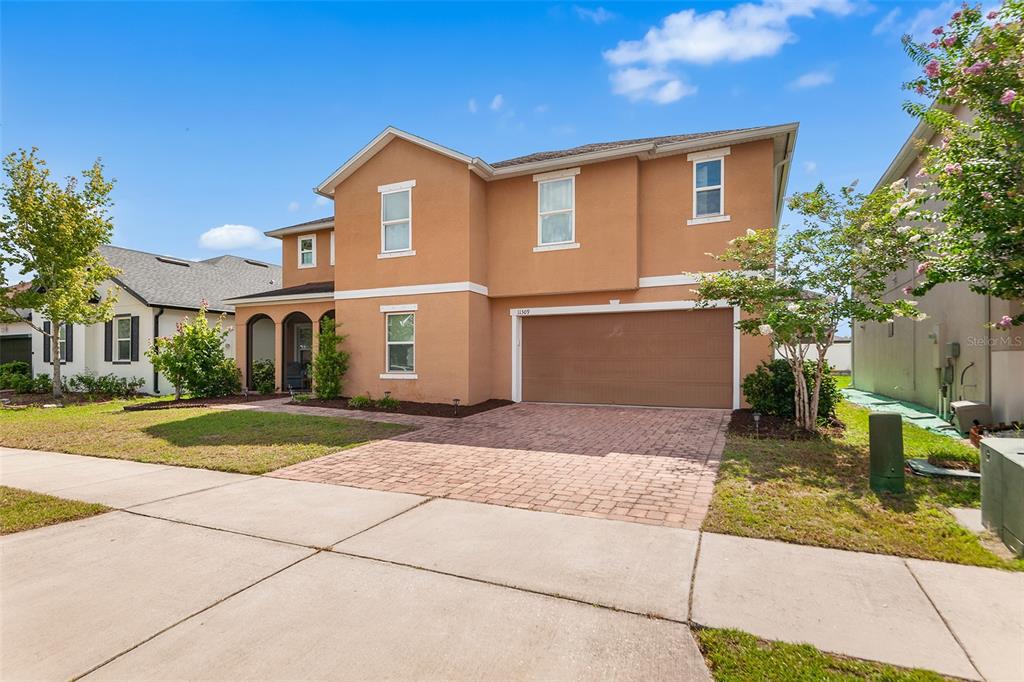 A two-story tan house features a brick driveway and a two-car garage — 11309 BRIGHTON KNOLL LOOP, RIVERVIEW, FL