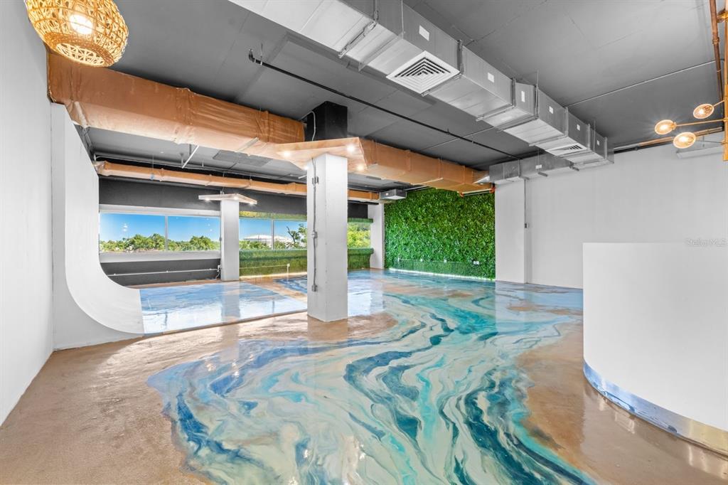 An open commercial space features a unique epoxy floor resembling water and a green wall — 100 CENTRO INTERNACIONAL DE MERCADEO UNIT 305, GUAYNABO, PR
