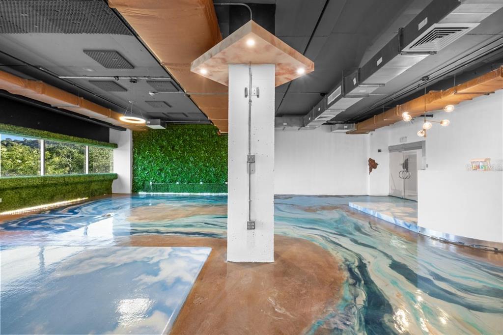 A modern interior space features a glossy, marbled floor, a central white pillar, and green walls — 100 CENTRO INTERNACIONAL DE MERCADEO UNIT 305, GUAYNABO, PR