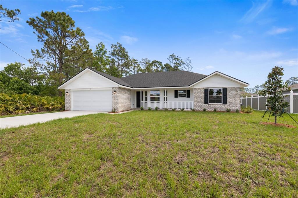 A single-story house with a brick facade, white siding, and a two-car garage — 2 ULMACEAL PATH, PALM COAST, FL