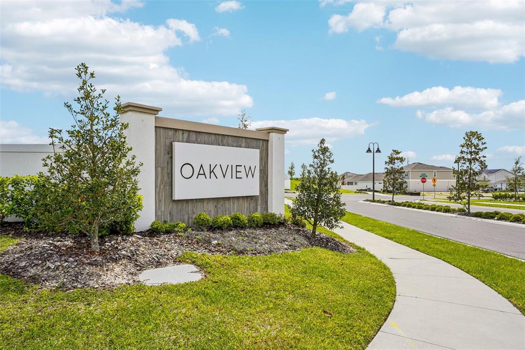 A neighborhood entrance sign for Oakview stands beside a sidewalk and a paved road — 4707 LAUREL SITE LOOP, APOPKA, FL