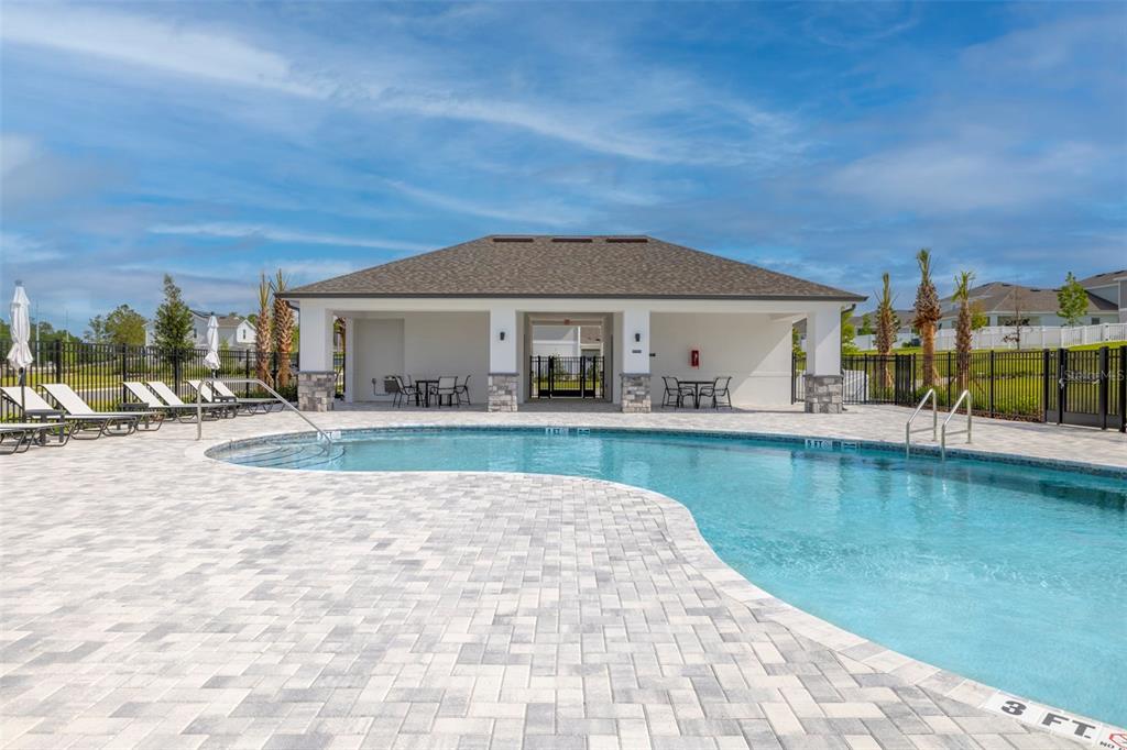 A swimming pool with a paved deck sits in front of a covered outdoor pavilion — 4707 LAUREL SITE LOOP, APOPKA, FL