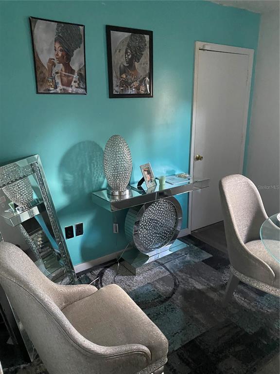 A dining area features a mirrored console table, two upholstered chairs, and teal walls — 5520 20TH STREET, ZEPHYRHILLS, FL