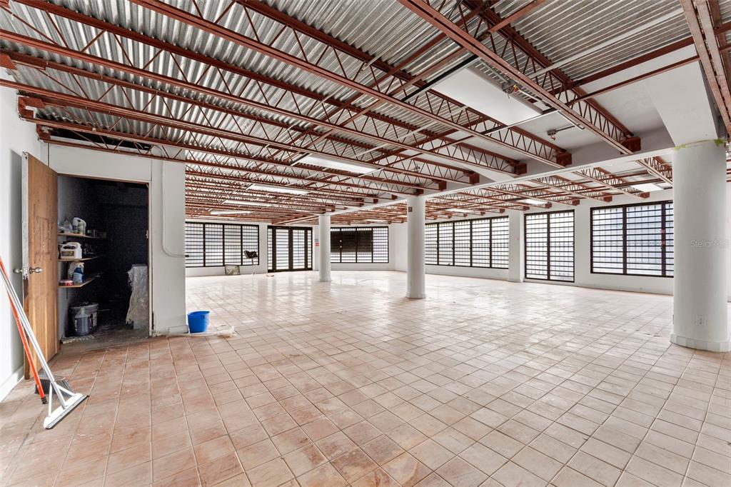 An open-plan commercial space features a tiled floor, exposed metal ceiling joists, and large windows — 241 ELEANOR ROOSEVELT AVENUE, SAN JUAN, PR