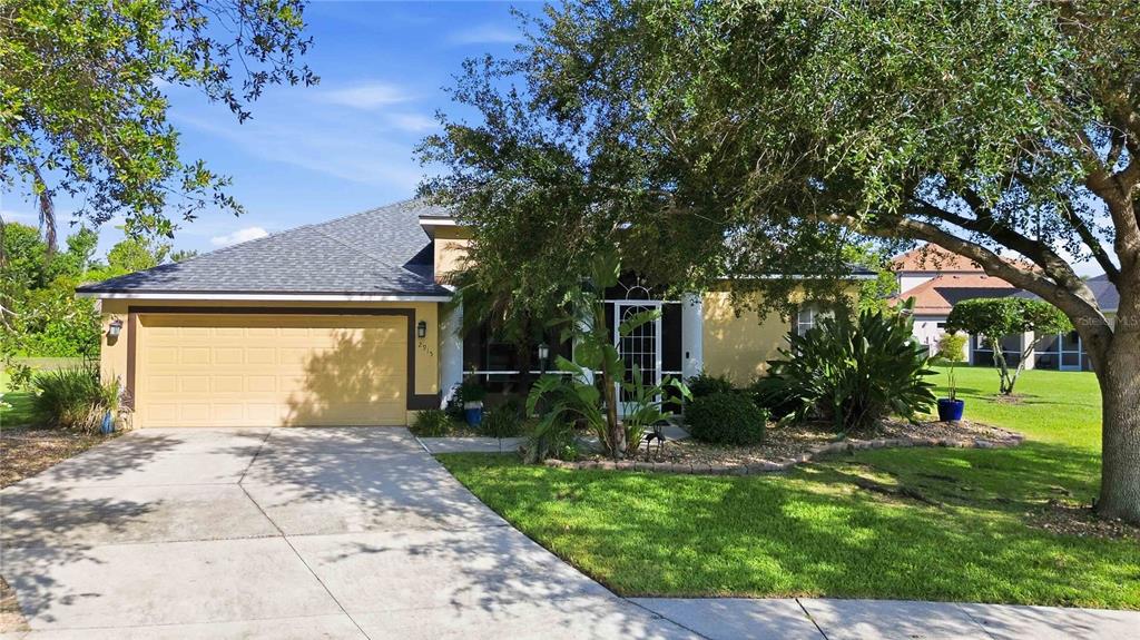 A single-story house with a tan stucco exterior, a two-car garage, and a screened entryway — 2915 126TH TERRACE E, PARRISH, FL