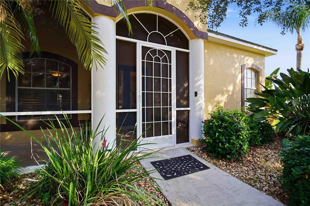 A screened front entryway features a white arched storm door and a concrete walkway — 2915 126TH TERRACE E, PARRISH, FL