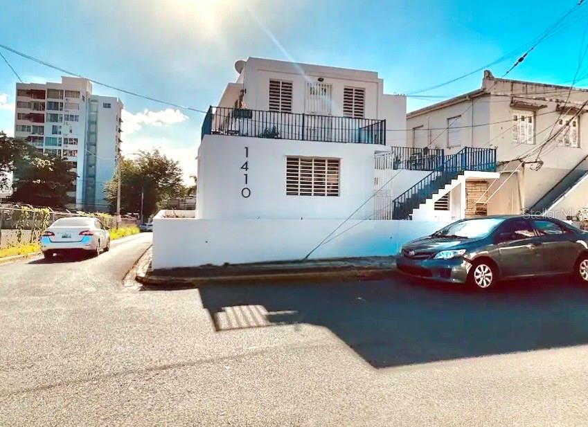 A white two-story building with a balcony, exterior staircase, and the number 1410 displayed — 1410 EDUARDO GEORGETTI, SAN JUAN, PR
