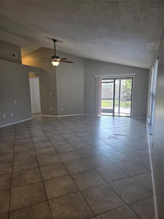 A spacious living room features light gray walls, a vaulted ceiling, and diagonal floor tiles — 787 ARTHURS COURT, TARPON SPRINGS, FL
