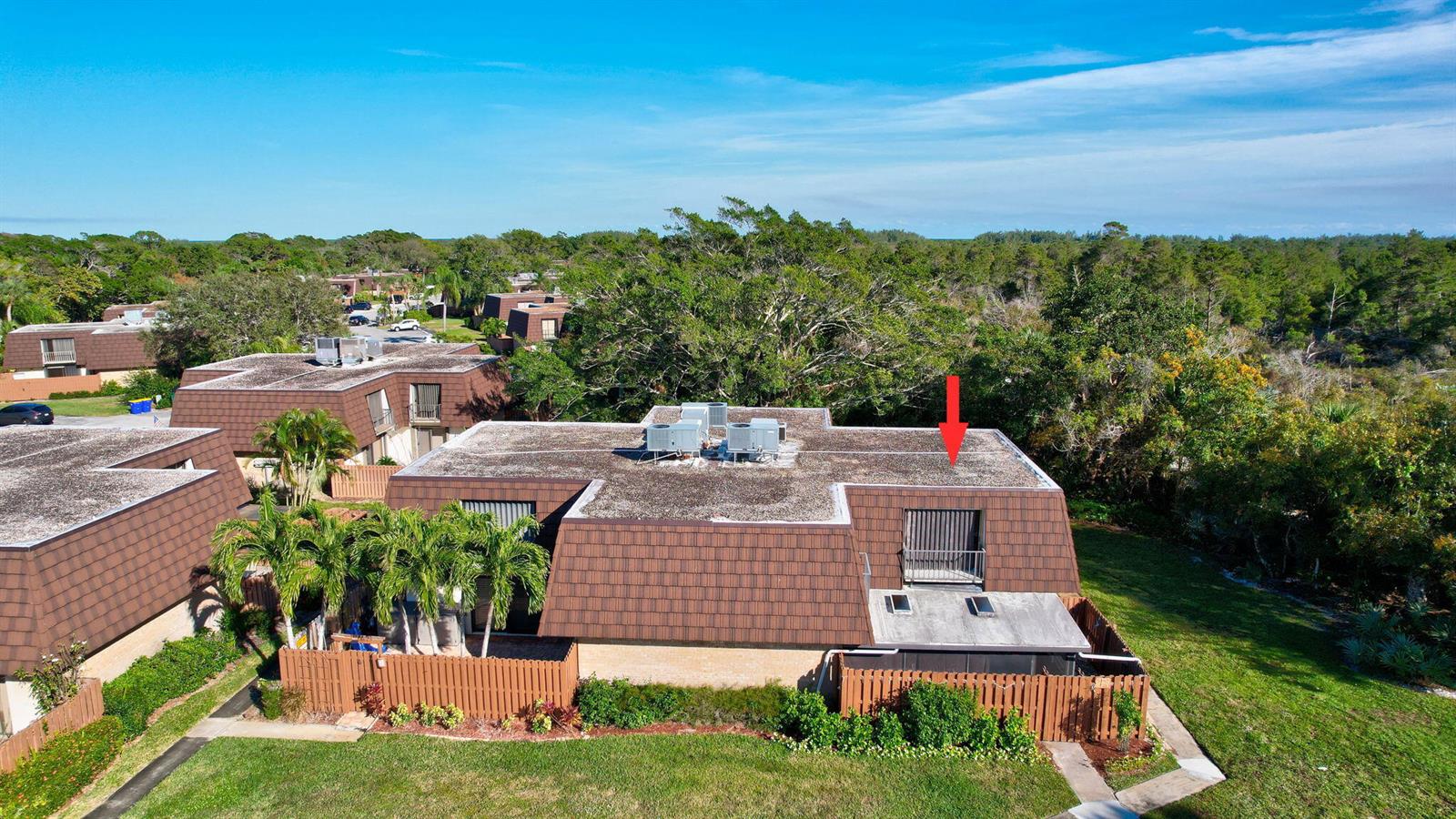 An aerial view of a multi-unit residential building with brown mansard roofs and green landscaping — 5852 SE Riverboat Drive # 321, Stuart FL 34997, STUART, FL