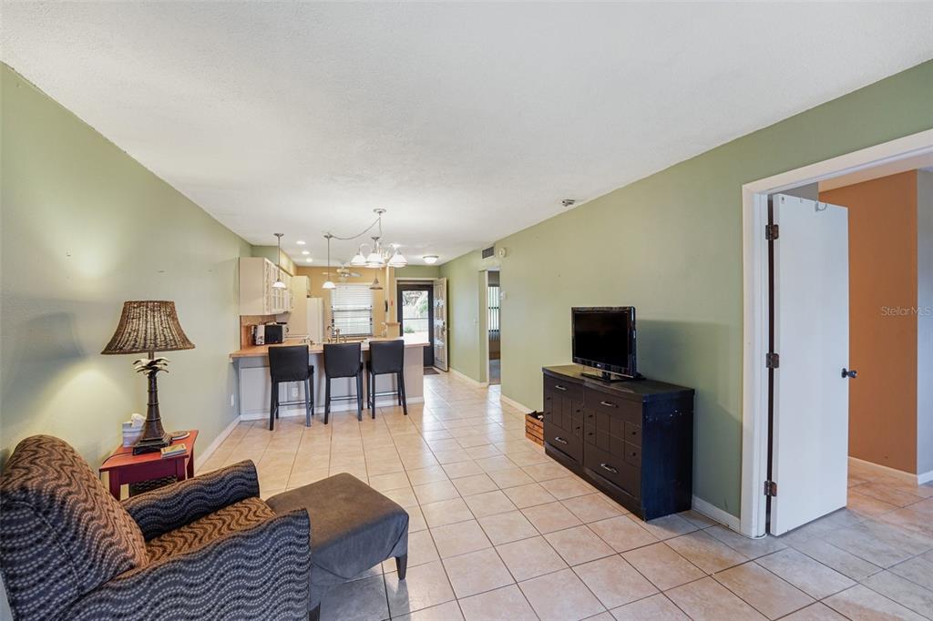 A kitchen features a large island with a sink, bar seating, and light-colored cabinetry — 4800 LAKE VILLA DRIVE, CLEARWATER, FL