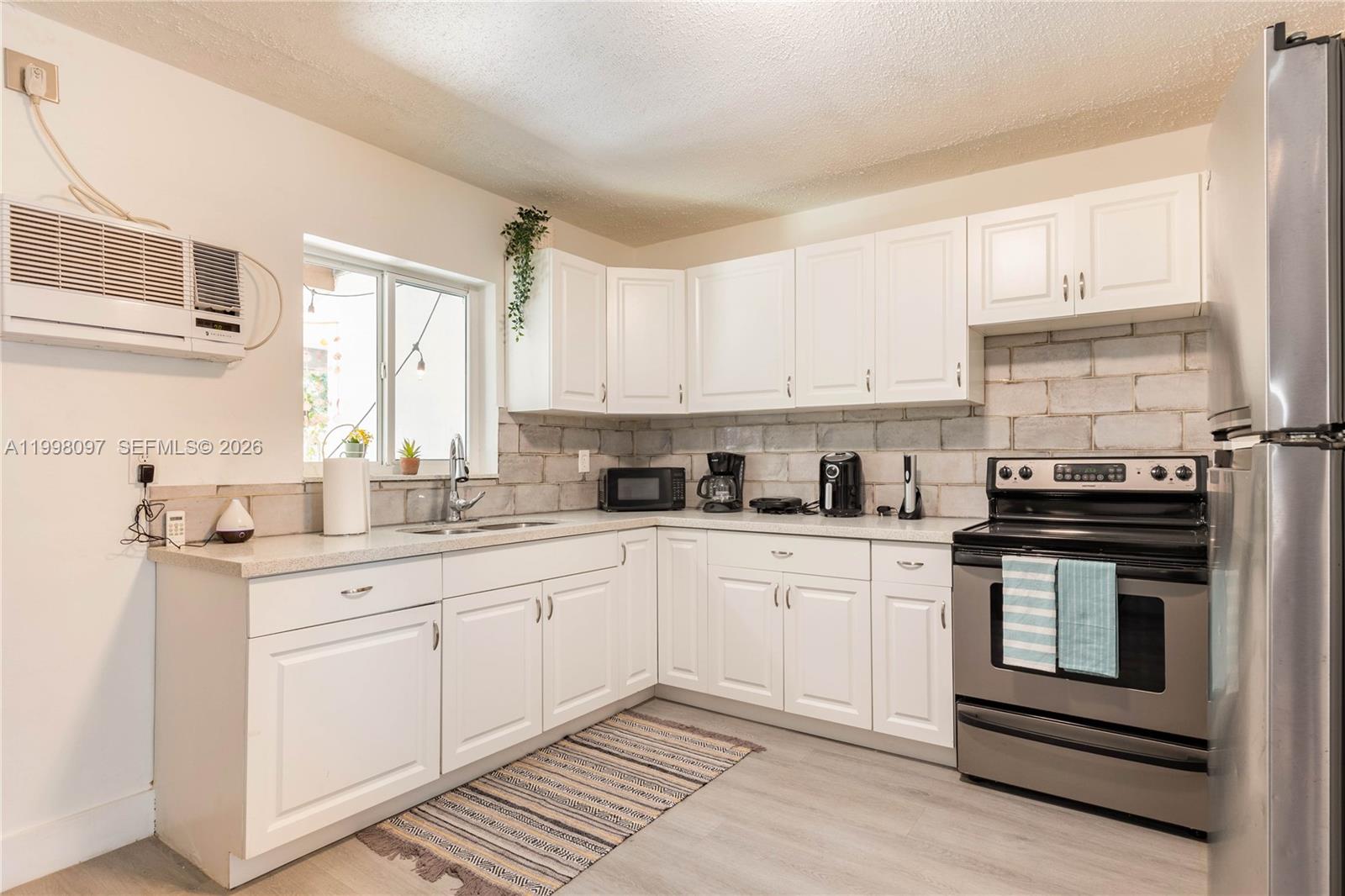 A brick-faced house exterior features a covered porch with a bench and two doors — 20 SE 13th Ter # 2, Dania Beach FL 33004, DANIA BEACH, FL