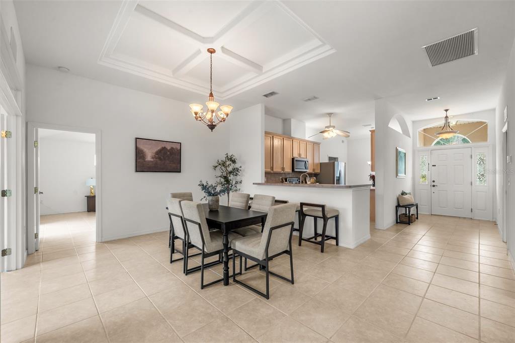 A dining area with a chandelier and a kitchen counter with bar stools — 11295 SW 73RD CIRCLE, OCALA, FL