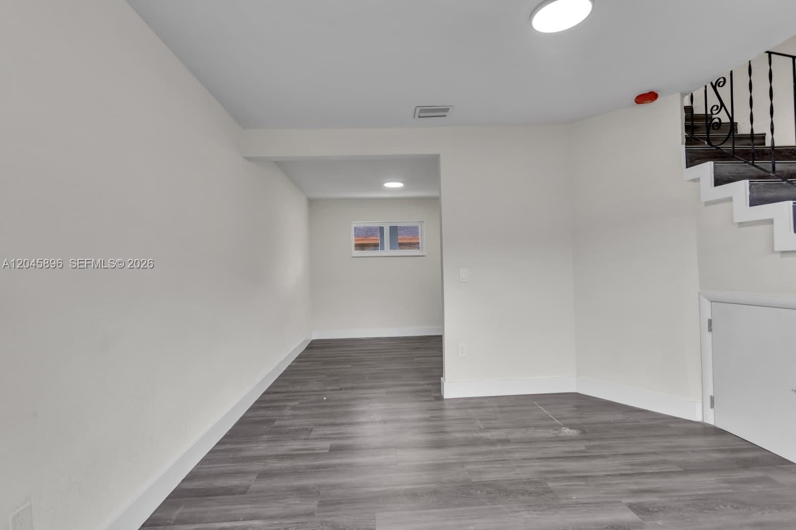 An interior room features gray wood-look flooring, white walls, recessed lighting, and a staircase — 1430 NW 2nd Ave # 2, Florida City FL 33034, FLORIDA CITY, FL