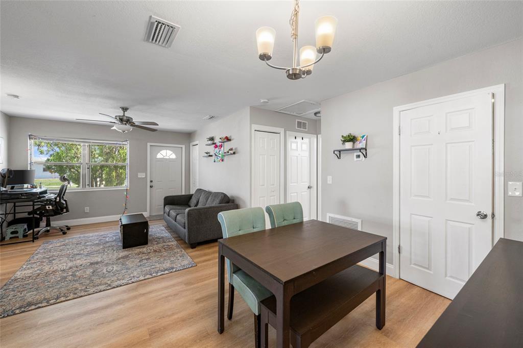 A living and dining area features light wood flooring, gray walls, and a ceiling fan — 8725 AERO AVENUE, NORTH PORT, FL
