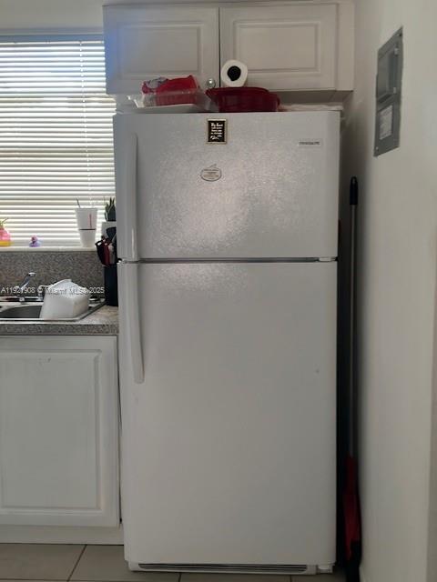 A white top-freezer refrigerator stands in a kitchen next to a sink and window — 1370 NE 119th St # 137014, Miami FL 33161, MIAMI, FL