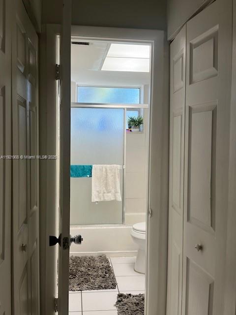 A view through a doorway into a bathroom with a shower, toilet, and tiled floors — 1370 NE 119th St # 137014, Miami FL 33161, MIAMI, FL