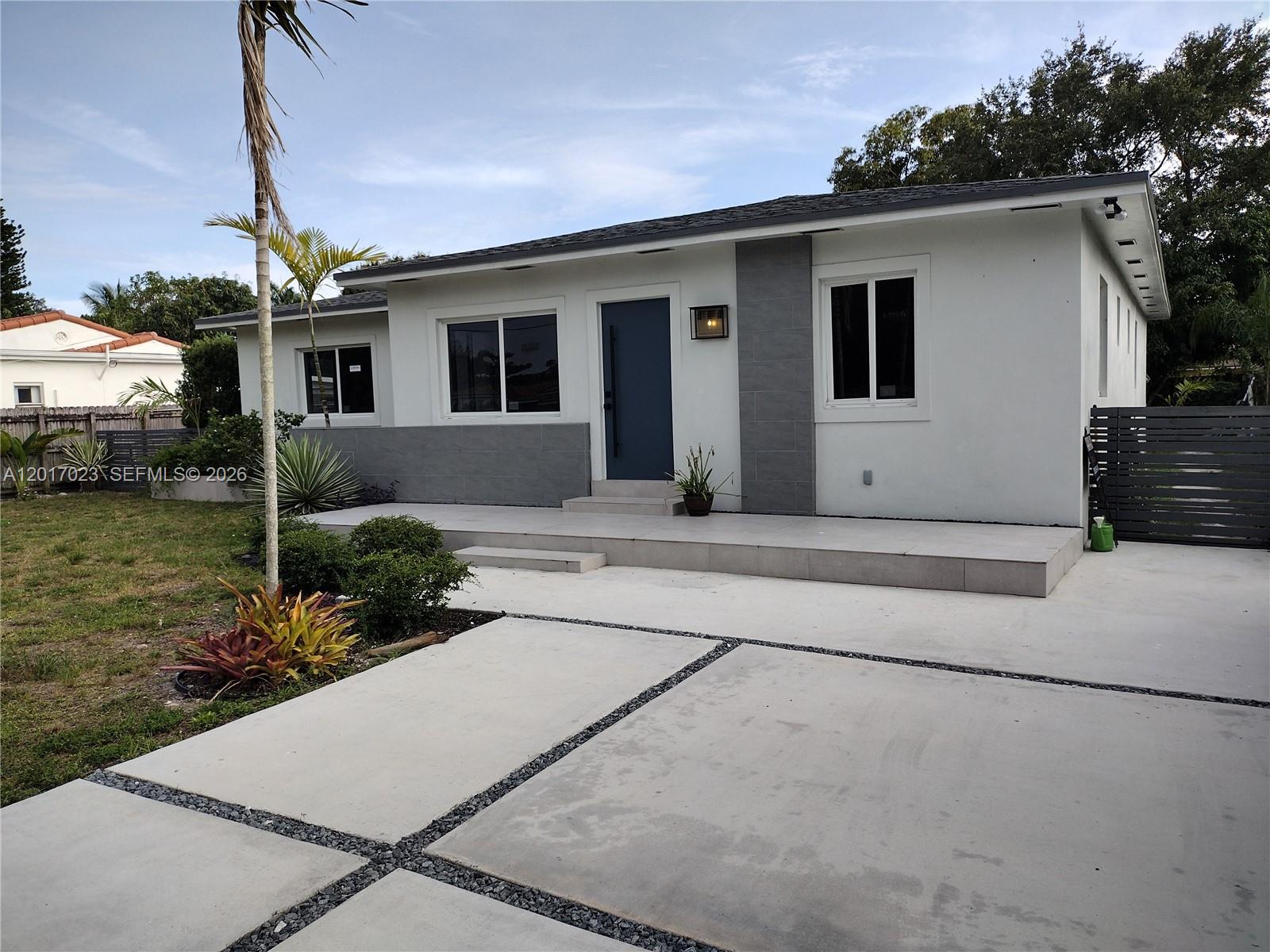 A single-story house with a white exterior, gray stone accents, and a paved concrete driveway — 300 S Biscayne River Dr, Miami FL 33169, MIAMI, FL