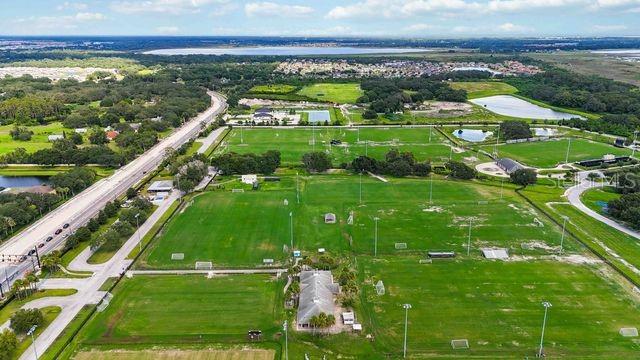 Aerial view of a large sports complex with multiple soccer fields and a central building — 4121 BOGGY CREEK ROAD, KISSIMMEE, FL