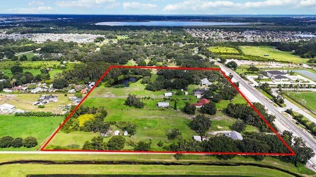 An aerial view shows a large, rectangular plot of land outlined in red near a road — 4121 BOGGY CREEK ROAD, KISSIMMEE, FL