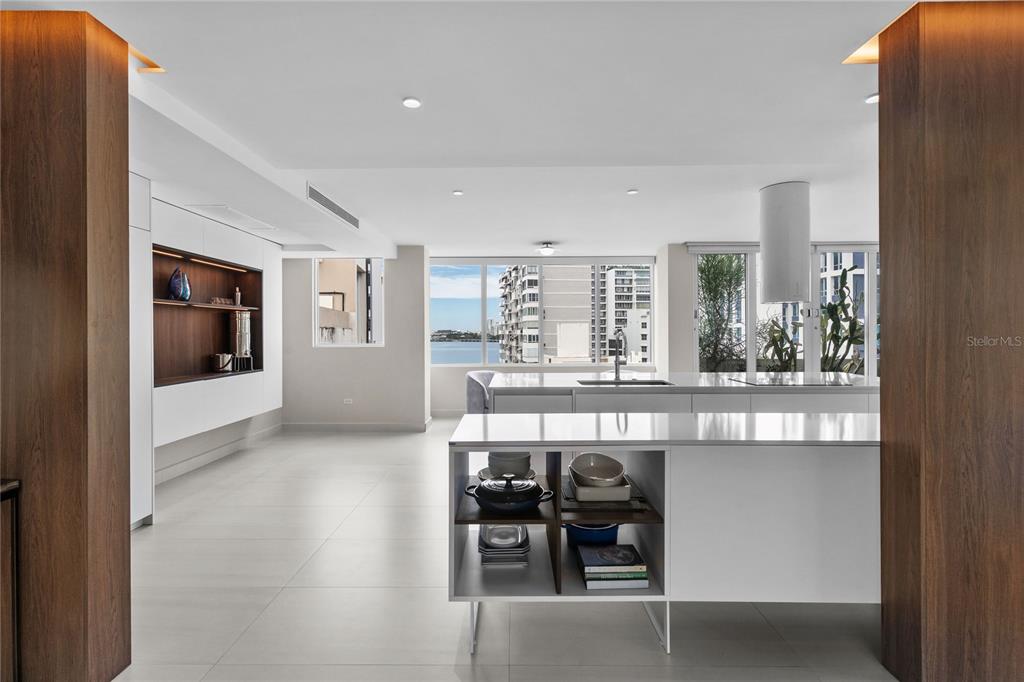 A modern kitchen with white cabinetry, a central island, and a view of the water — 1115 CALLE PICCIONI UNIT PH, SAN JUAN, PR