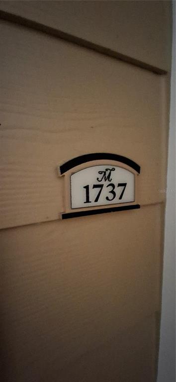 A close-up view of a beige exterior wall featuring a decorative address plaque labeled 1737 — 8539 GATE PARKWAY W UNIT 1737, JACKSONVILLE, FL