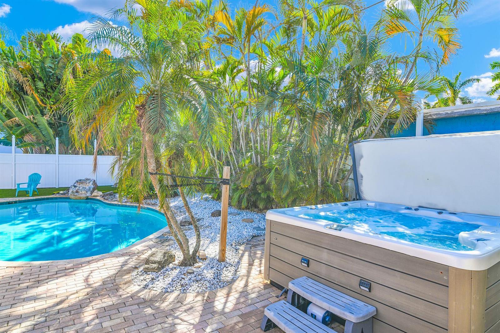 A backyard features a swimming pool, a hot tub with steps, and several palm trees — 3218 Palm Drive, Delray Beach FL 33483, DELRAY BEACH, FL