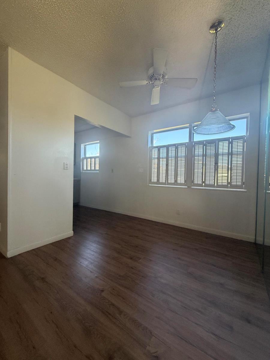 A room with wood-look flooring, a ceiling fan, a pendant light, and plantation shutters — 64 Norwich C, West Palm Beach FL 33417, WEST PALM BEACH, FL
