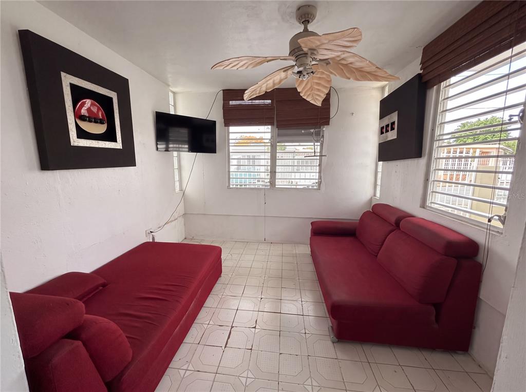A dining room features a wooden table with four chairs, a hutch, and tiled flooring — 187 ROMAGUERA STREET, MAYAGUEZ, PR