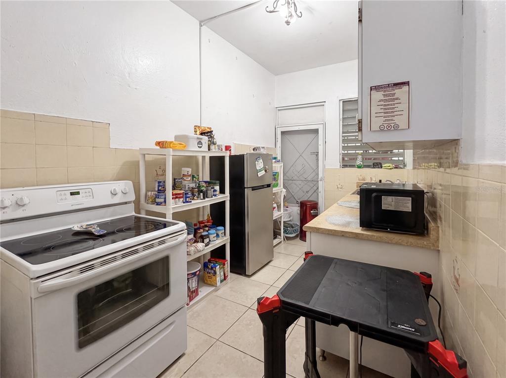 A sunroom features two red sofas, a ceiling fan, and tiled flooring — 187 ROMAGUERA STREET, MAYAGUEZ, PR