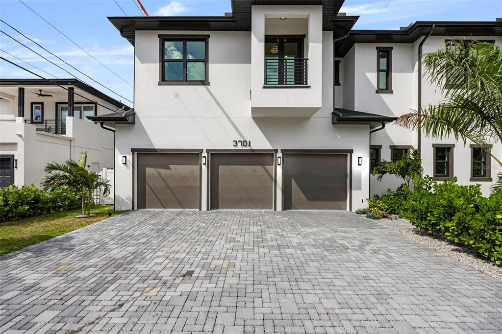 A modern two-story house features a three-car garage and a paved driveway — 3701 S LYNWOOD AVENUE, TAMPA, FL