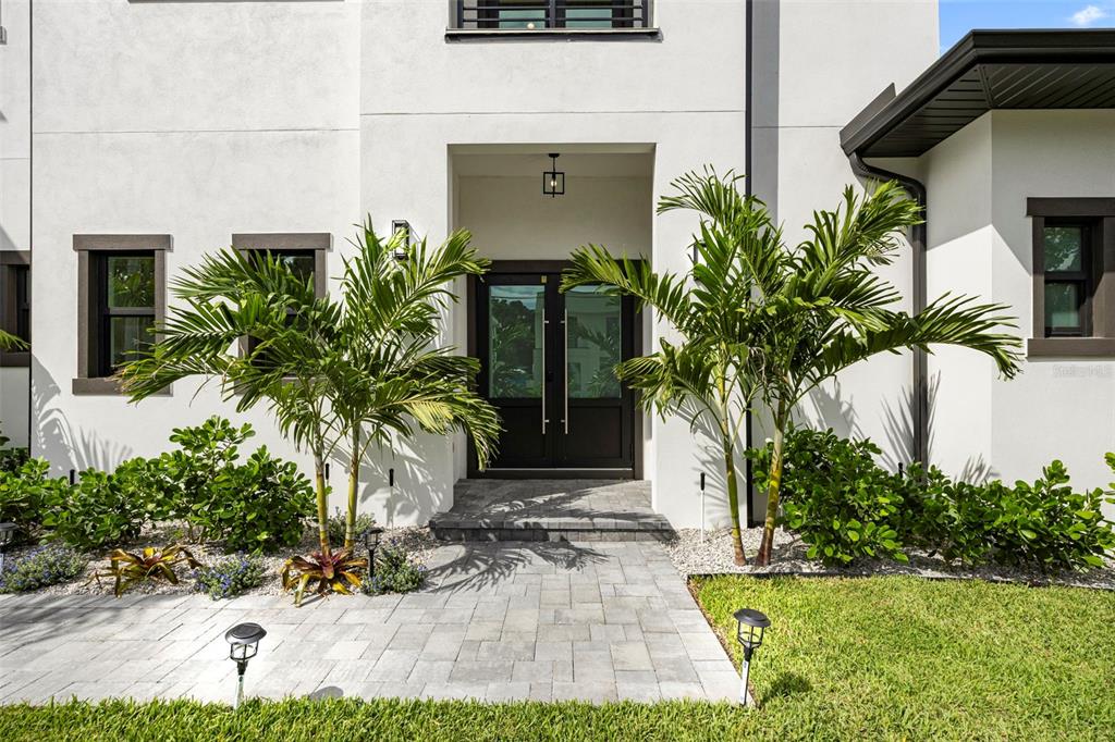 The front entrance of a modern white house features double doors and two palm trees — 3701 S LYNWOOD AVENUE, TAMPA, FL