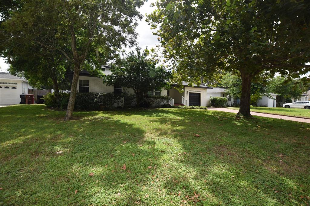 A single-story white brick house sits behind a large lawn with mature trees — 924 BOARDMAN STREET, ORLANDO, FL