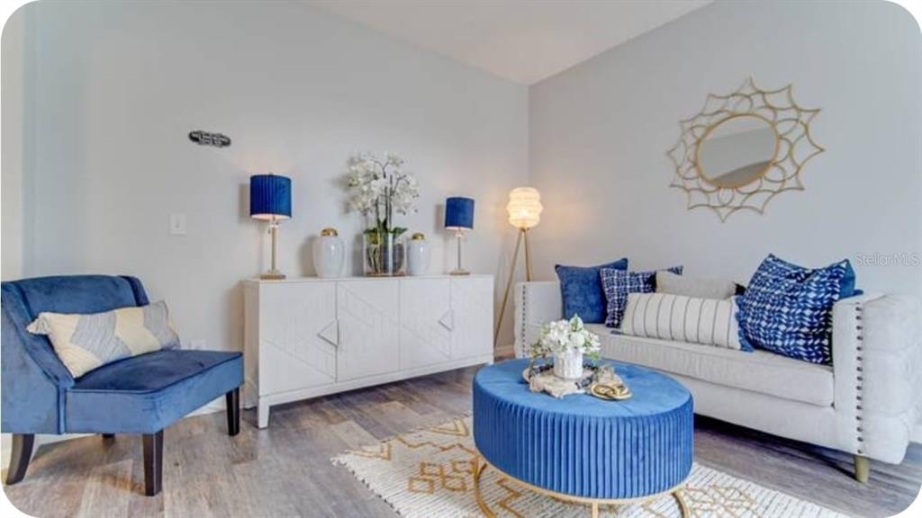 A living room features a white sofa, blue velvet chair, round ottoman, and white sideboard — 238 SUNSET VIEW DRIVE, DAVENPORT, FL