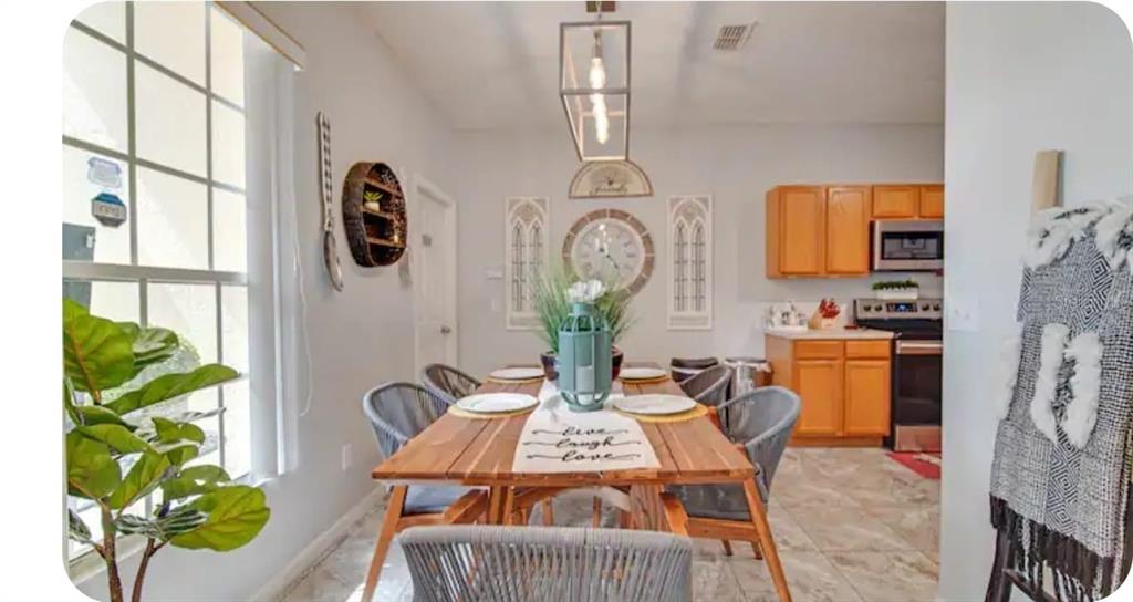 A dining area with a wooden table, gray chairs, a pendant light, and adjacent kitchen — 238 SUNSET VIEW DRIVE, DAVENPORT, FL