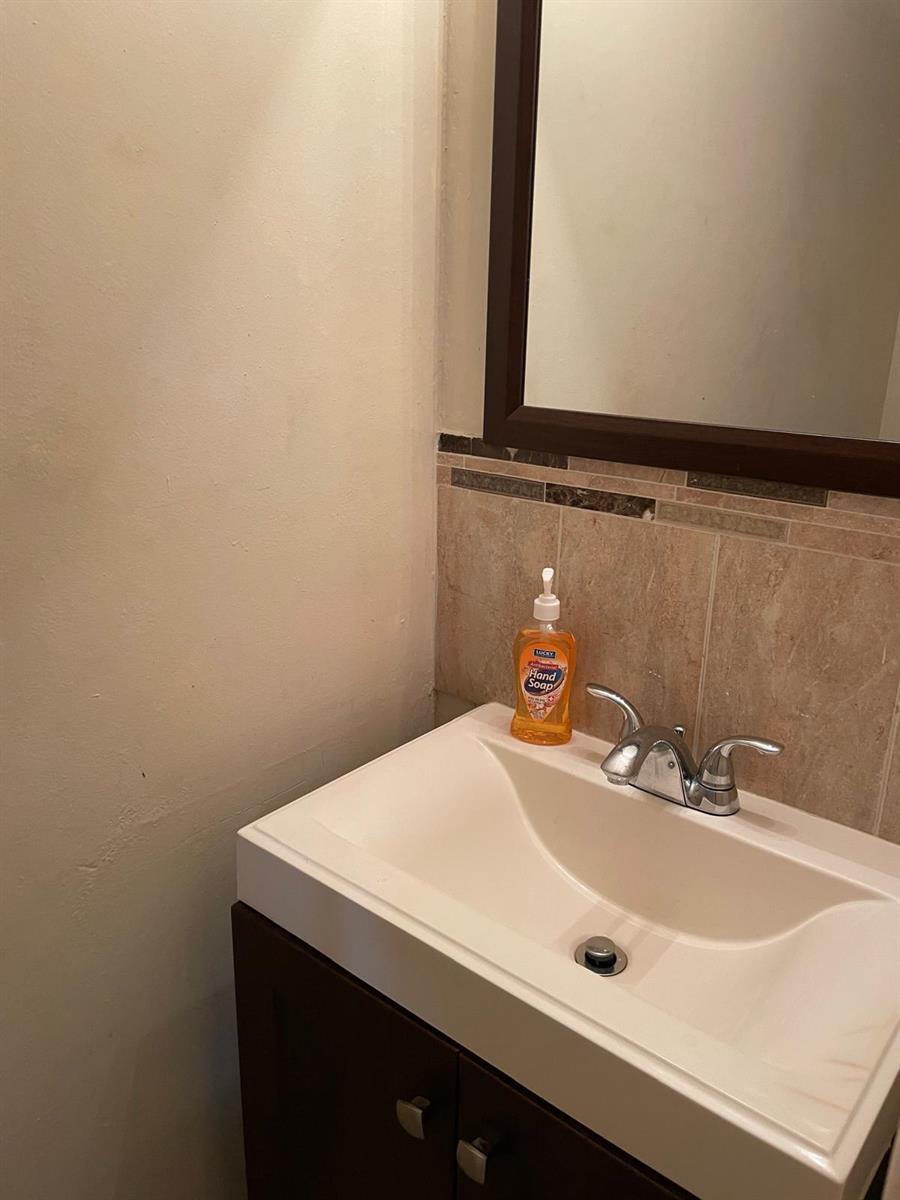A bathroom vanity features a white sink, chrome faucet, and a bottle of hand soap — 8249 Fairway Road, Sunrise FL 33351, SUNRISE, FL
