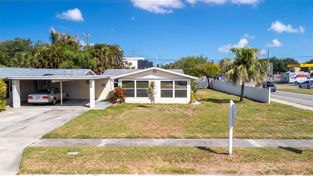 A single-story house with a carport and a front lawn sits beside a road — 2463 TERRY LANE, SARASOTA, FL