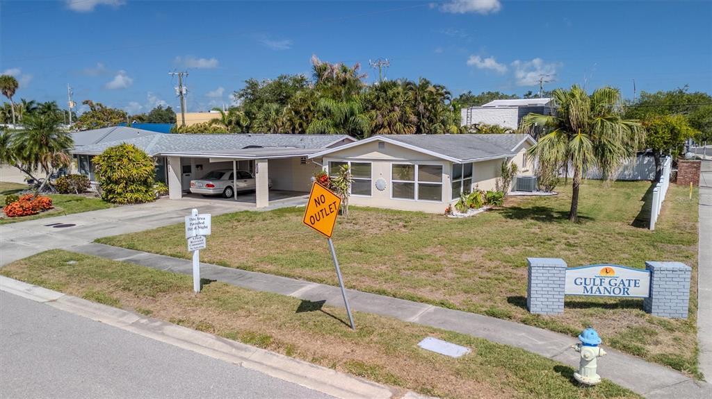 A single-story house with a carport and a Gulf Gate Manor sign on the lawn — 2463 TERRY LANE, SARASOTA, FL