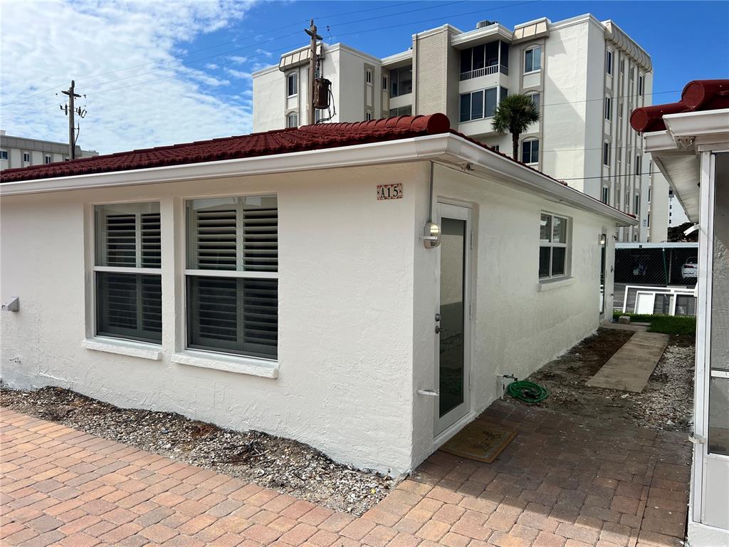 A white, single-story building with a red tile roof and unit number A15 — 6154 MIDNIGHT PASS ROAD UNIT A15, SARASOTA, FL