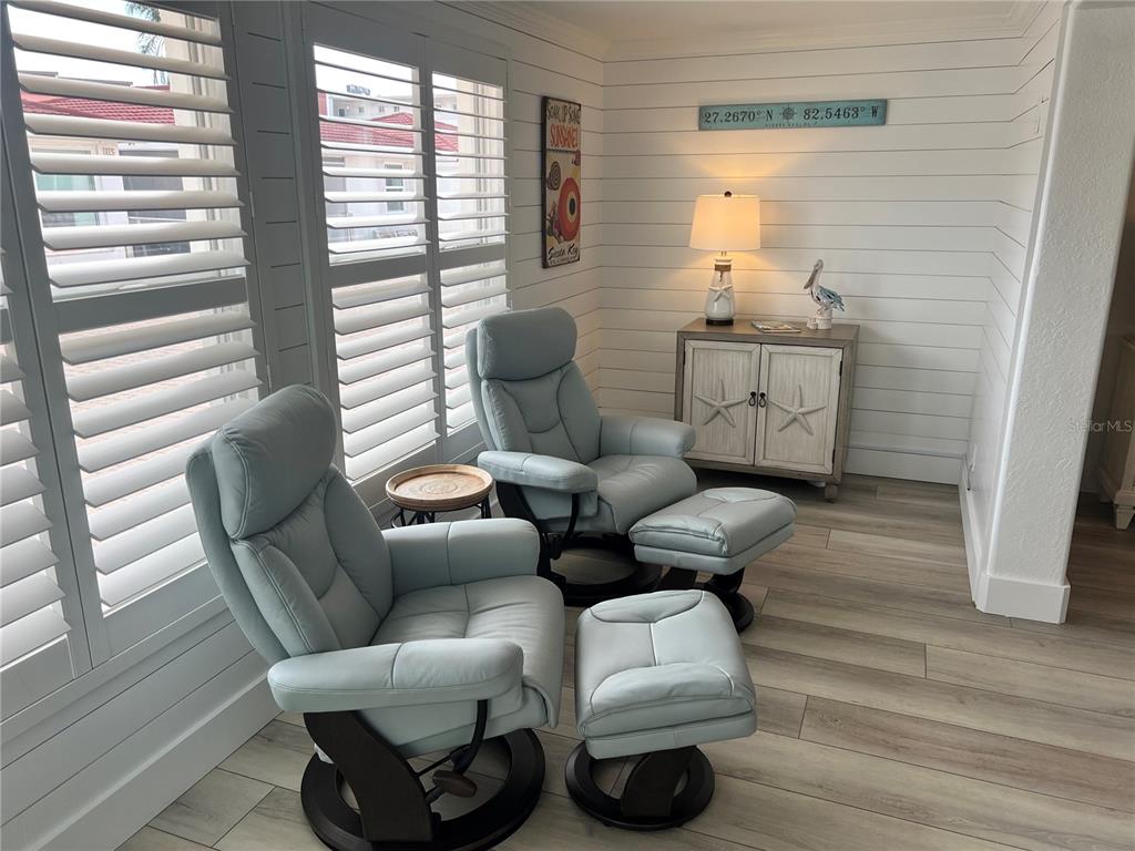 A room with two light blue leather recliners, white shiplap walls, and plantation shutters — 6154 MIDNIGHT PASS ROAD UNIT A15, SARASOTA, FL