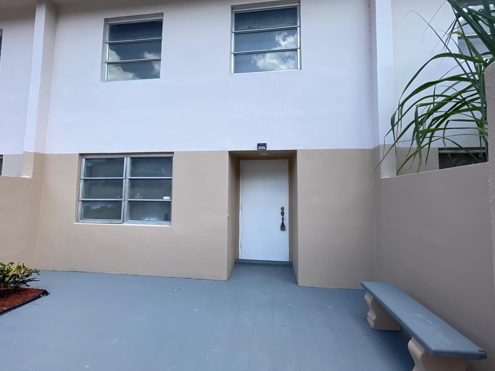 The exterior view shows a white door, a window, and a bench on a patio — 4140 Inverrary Drive # 15e, Lauderhill FL 33319, LAUDERHILL, FL