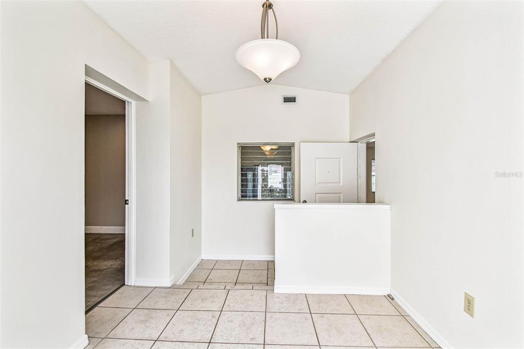 An entryway with tiled flooring, a pendant light, a half wall, and a window — 1101 81ST AVENUE N, ST PETERSBURG, FL