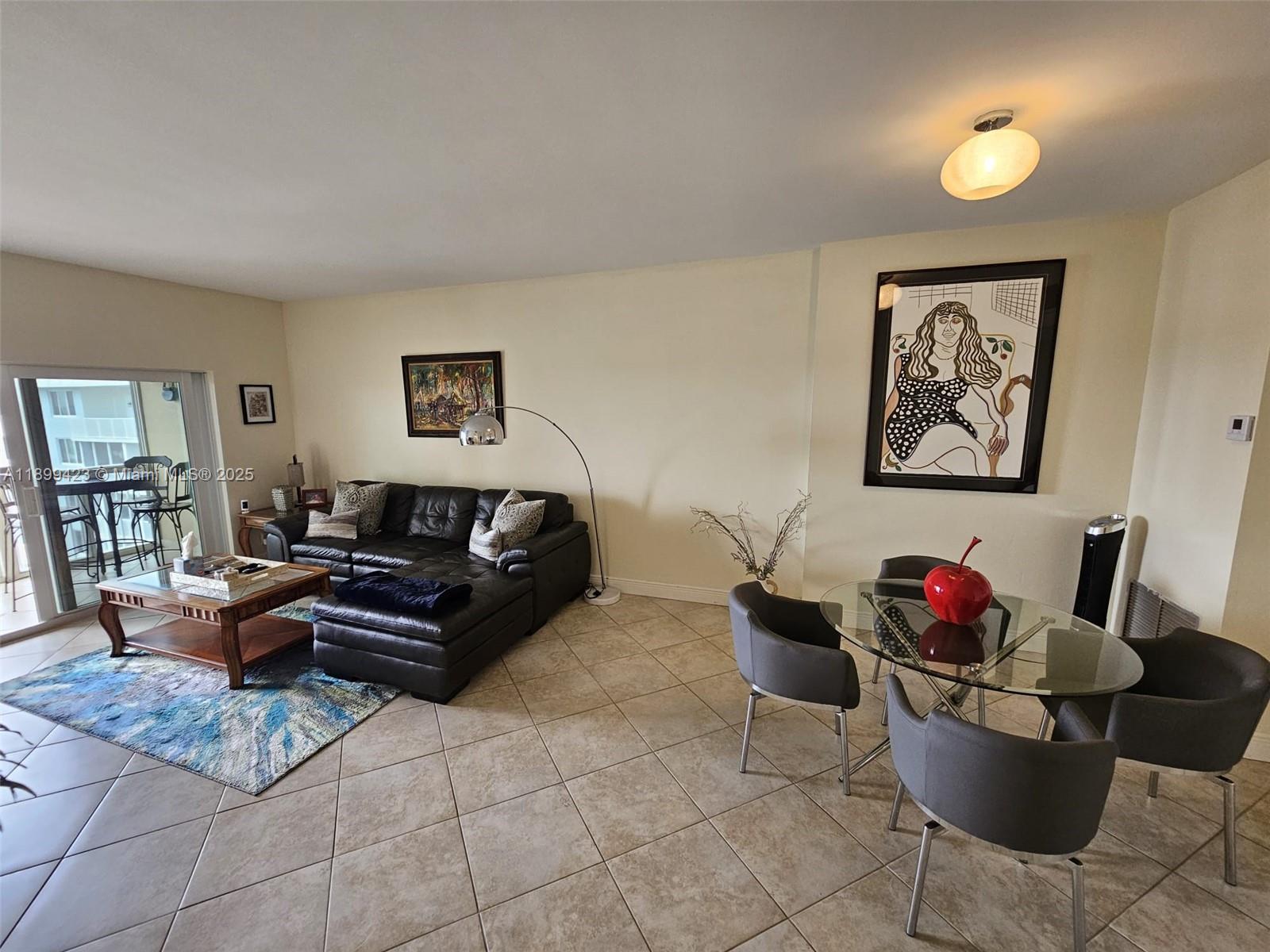 A living and dining area features tile floors, a leather sectional, and a glass table — 4200 Hillcrest Dr # 1015, Hollywood FL 33021, HOLLYWOOD, FL