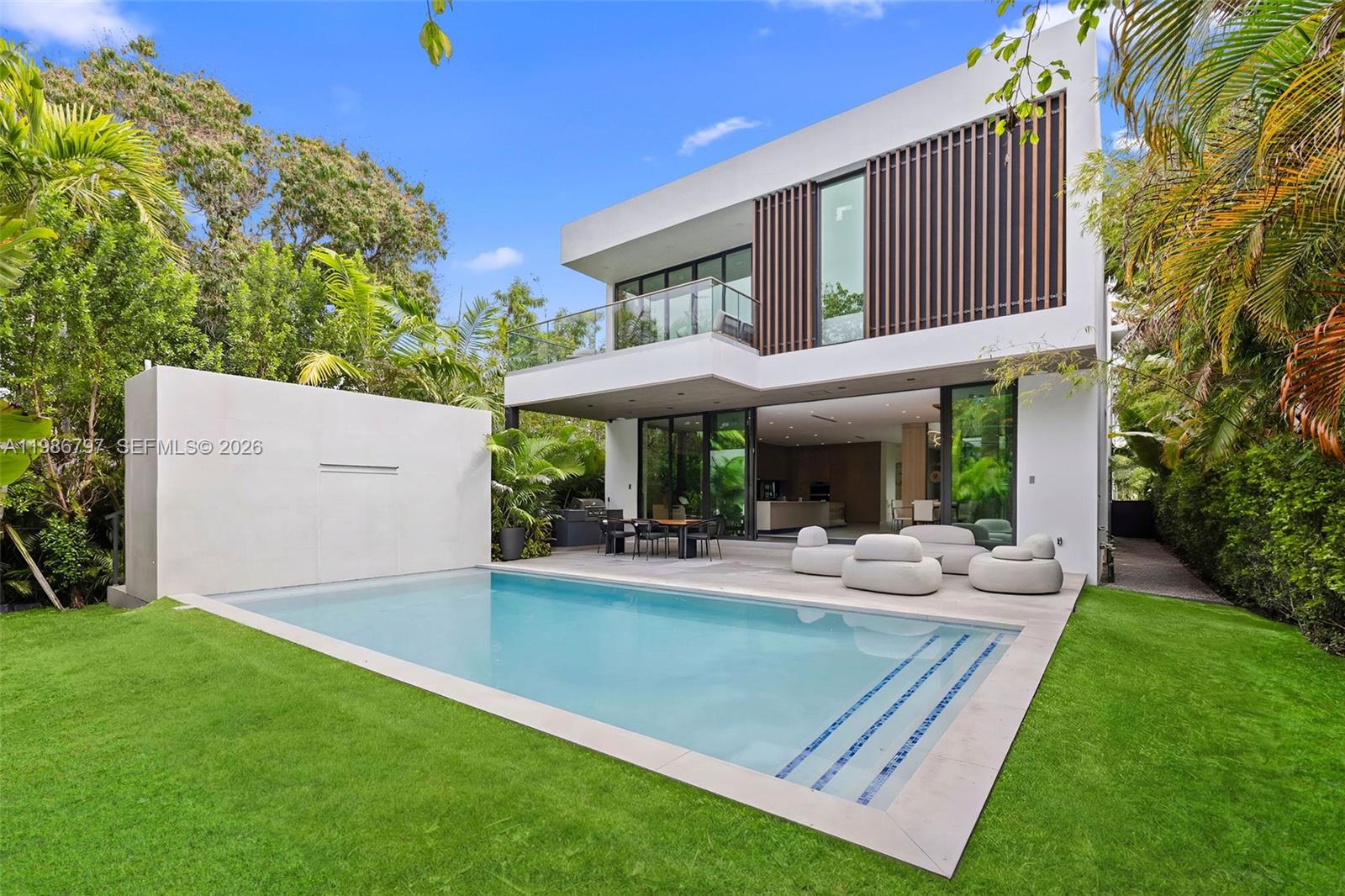 A modern two-story house features a swimming pool, a patio, and a white privacy wall — 4534 Sheridan Ave, Miami Beach FL 33140, MIAMI BEACH, FL