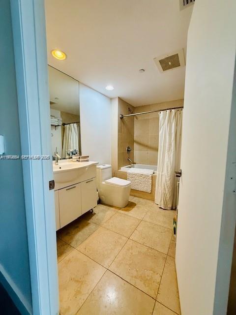 A bathroom features a white vanity, a toilet, and a shower-tub combination with beige tile — 475 Brickell Ave # 4910, Miami FL 33131, MIAMI, FL