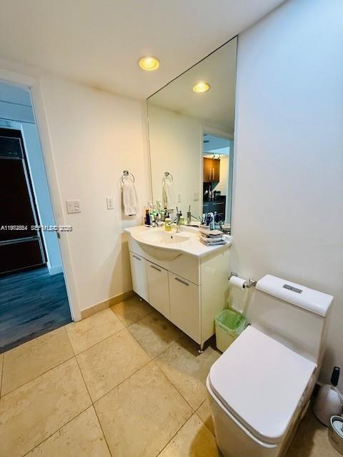 A bathroom features a white vanity, a large wall mirror, and a white toilet — 475 Brickell Ave # 4910, Miami FL 33131, MIAMI, FL