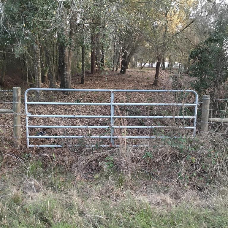 A metal farm gate is installed between two wooden posts at the edge of woods — 0 ALTURAS BABSON PARK CUTOFF ROAD Lot 78, BARTOW, FL