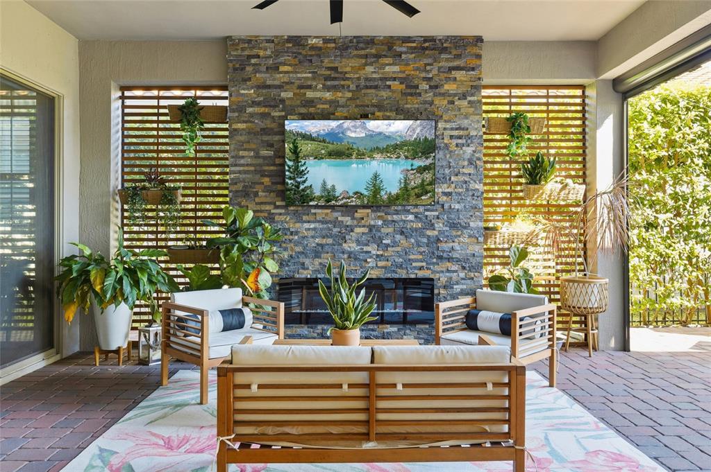 An open-concept living and dining area features light wood floors, a fireplace, and sliding doors — 10254 BEECHWOOD LANE, ORLANDO, FL