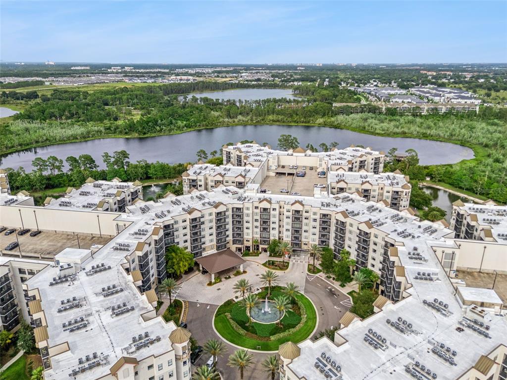 An aerial view shows a large multi-story apartment complex with a central fountain courtyard — 14501 GROVE RESORT AVENUE UNIT 1726, WINTER GARDEN, FL