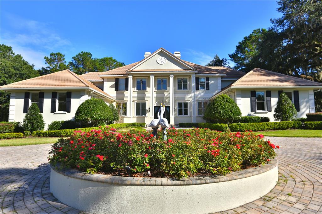 A large two-story house with a circular driveway and a central rose garden — 4026 NW 85TH TERRACE, OCALA, FL